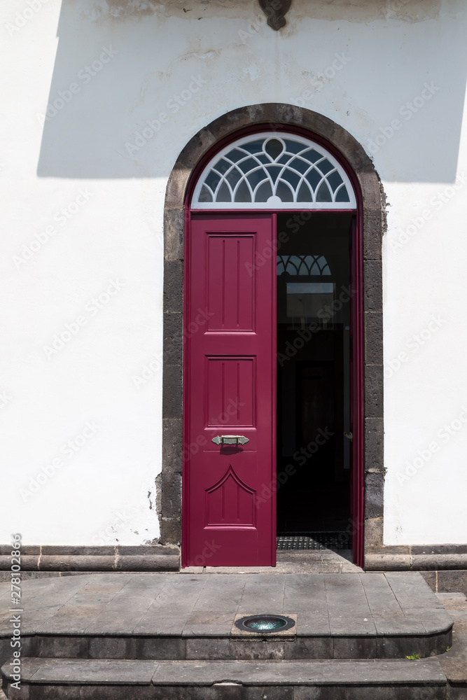Fototapeta premium Opened burgundy door of a house