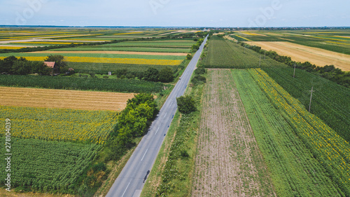 Asphalt road through fields and villages  aerial view
