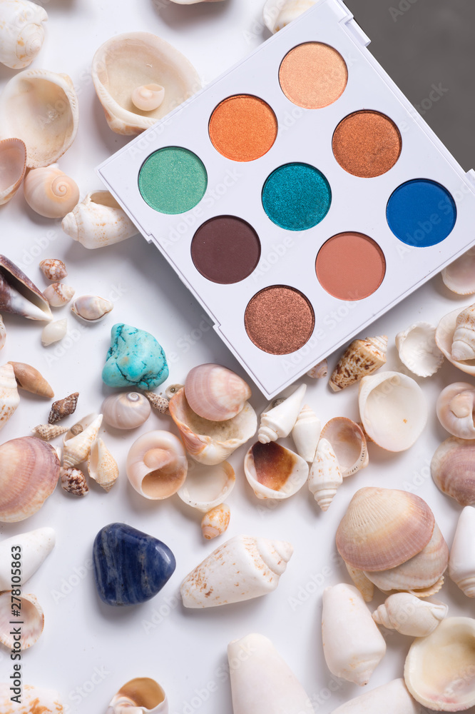 fashion summer eye palettes with natural shells and gemstones around background. close up fashion summer eye palettes with natural shells and gemstones around background. close up
