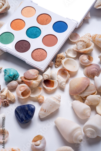 fashion summer eye palettes with natural shells and gemstones around background. close up