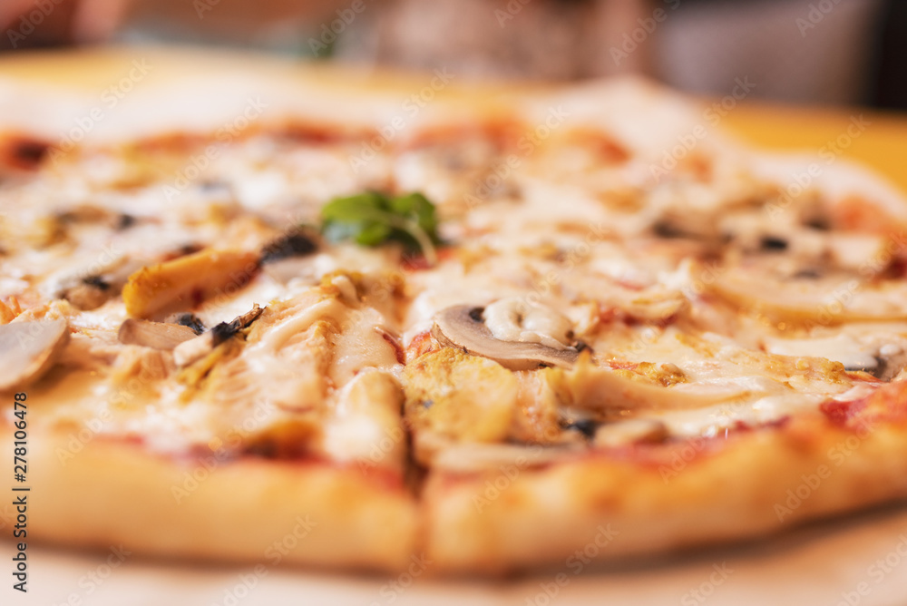Pizza with chicken and mushrooms champignons close-up in defocus