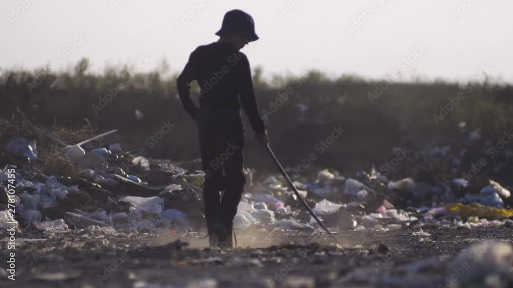 Bored boy making dust in dump Bored boy making dust in dump