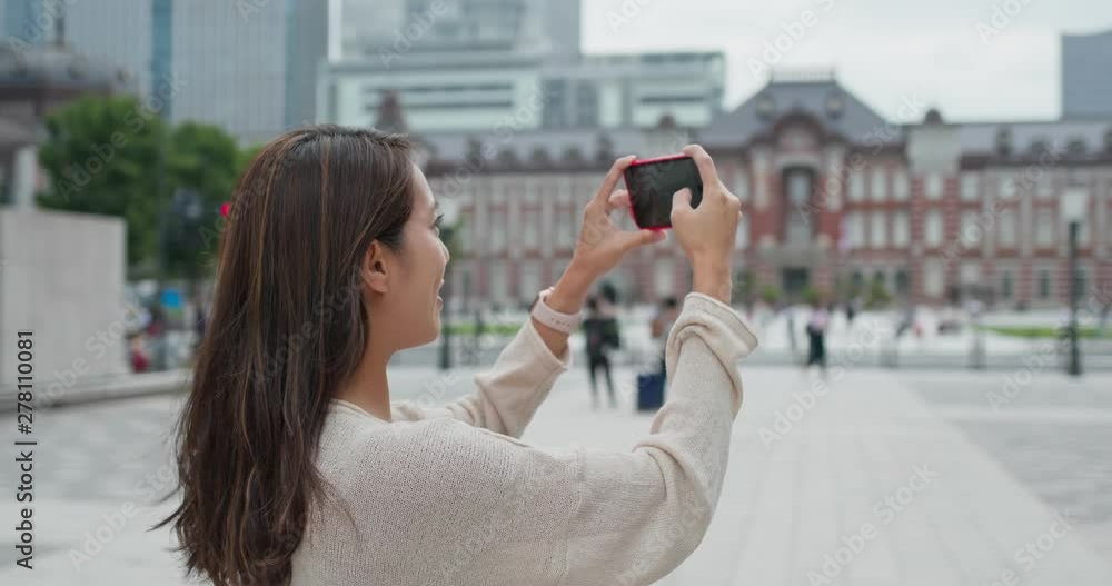 Woman take photo on cellphone in Tokyo station Woman take photo on cellphone in Tokyo station