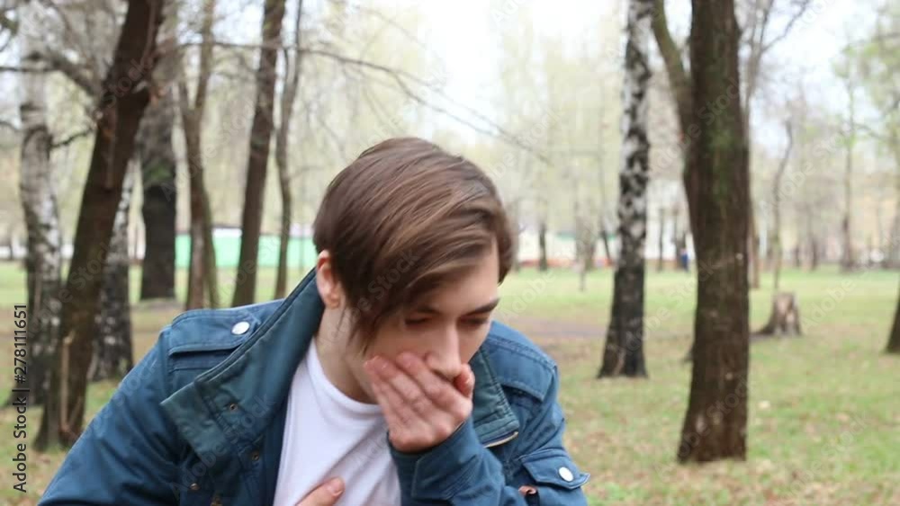 Portrait of handsome caucasian young man who is sneezes in the park Portrait of handsome caucasian young man who is sneezes in the park