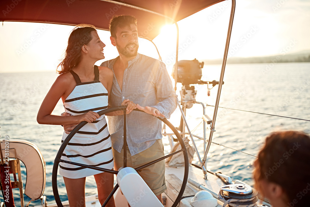 young girl sailing on the luxury boat with man and enjoy at sunset.