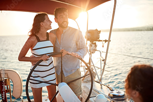 young girl sailing on the luxury boat with man and enjoy at sunset. © luckybusiness