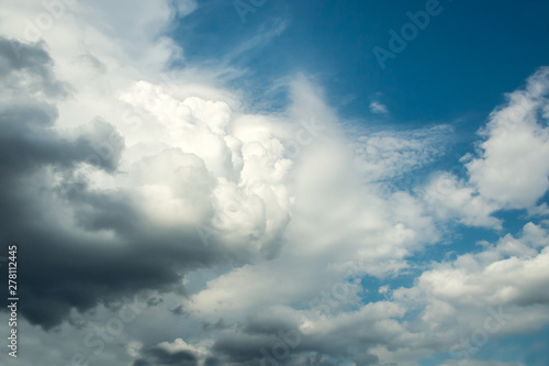 White curly clouds in a blue sky. Sky background