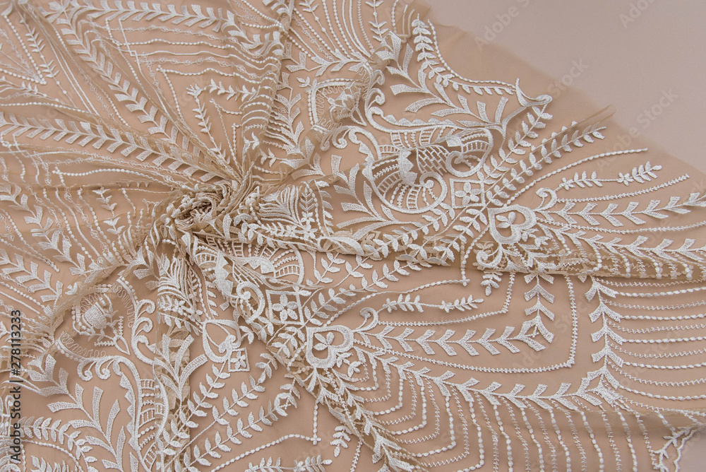 Texture lace fabric. lace on beige background studio. thin fabric made of yarn or thread. typically one of cotton or silk, made by looping, twisting, or knitting thread in patterns
