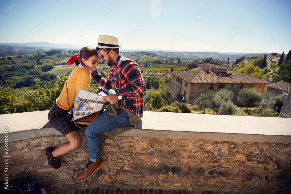 romantic man and girl using map as guide on vacation..