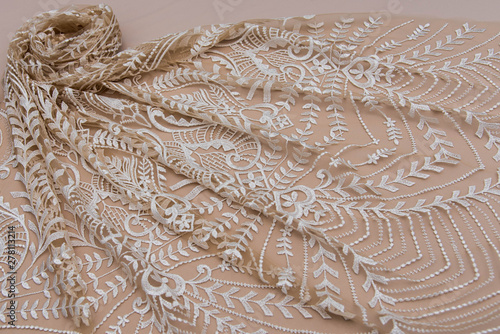 Texture lace fabric. lace on beige background studio. thin fabric made of yarn or thread. typically one of cotton or silk, made by looping, twisting, or knitting thread in patterns