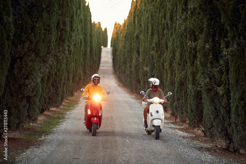 Happy man and girl riding a scooter outdoors.