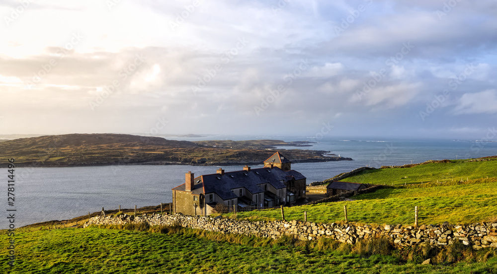 Fototapeta premium Green fields and houses on the coast, coastline and islands in a distance, Wiled Atlantic Way