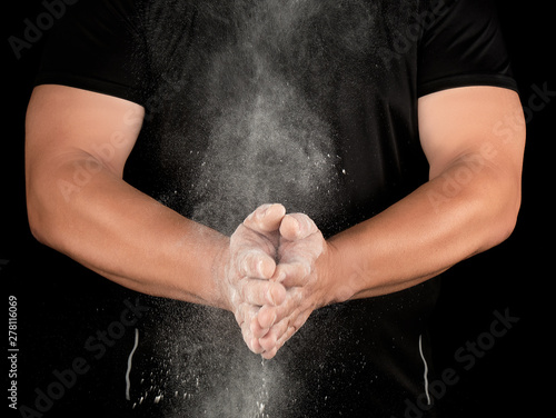 athlete in black clothes clapping, white talc magnesium fly away © nndanko