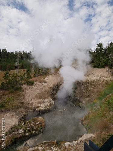 Steam and hot water sloshes out of the famous Dragon's Mouth Spring, one of the popular attractions at Yellowstone National Park.