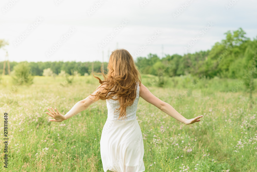 Beautiful and happy young girl running on the green field in a white dress Beautiful and happy young girl running on the green field in a white dress