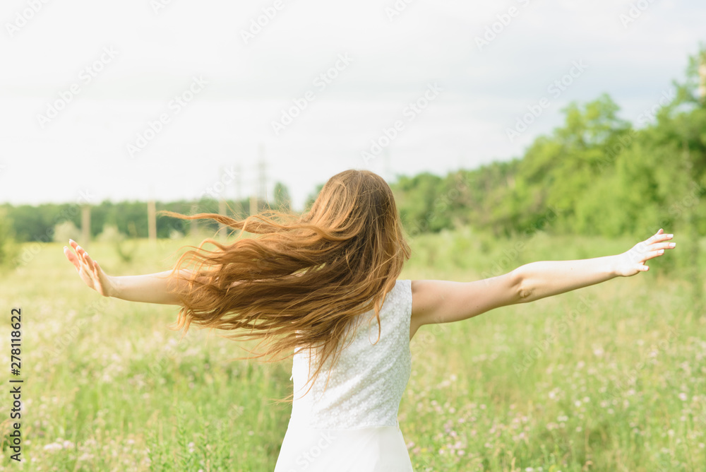 Beautiful and happy young girl running on the green field in a white dress Beautiful and happy young girl running on the green field in a white dress
