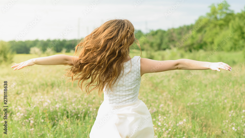 Beautiful and happy young girl running on the green field in a white dress Beautiful and happy young girl running on the green field in a white dress
