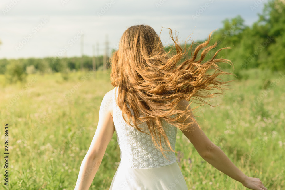 Beautiful and happy young girl running on the green field in a white dress Beautiful and happy young girl running on the green field in a white dress