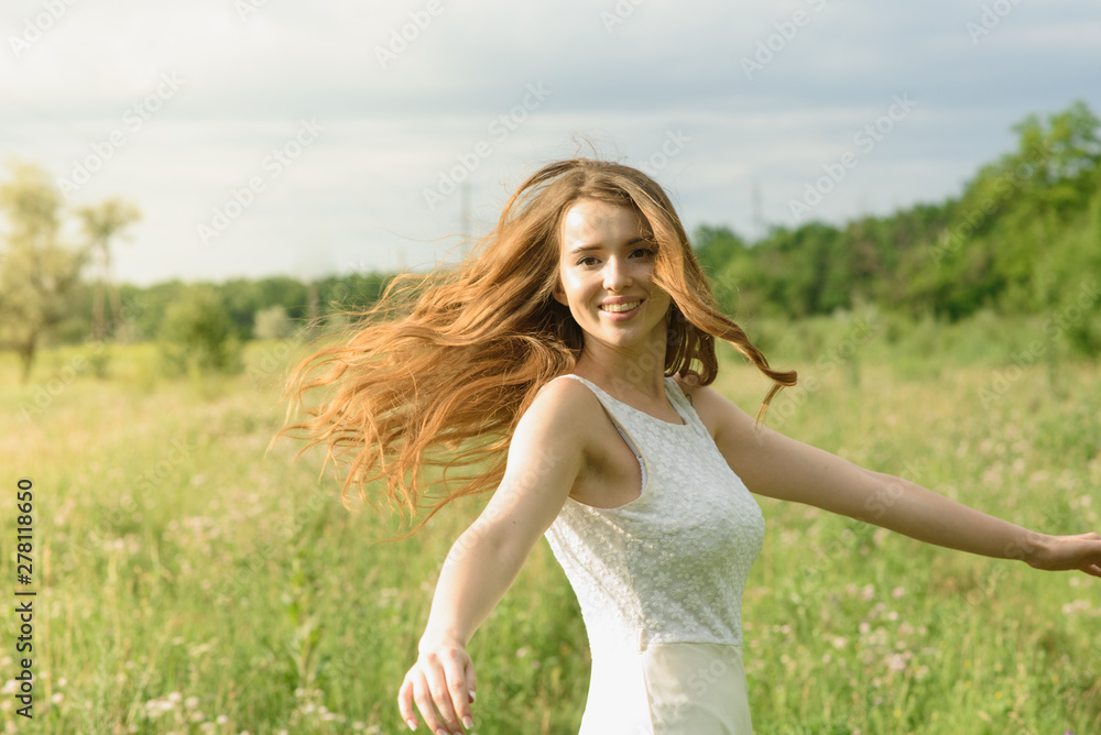 Beautiful and happy young girl running on the green field in a white dress Beautiful and happy young girl running on the green field in a white dress
