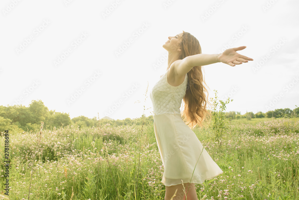Beautiful and happy young girl running on the green field in a white dress Beautiful and happy young girl running on the green field in a white dress