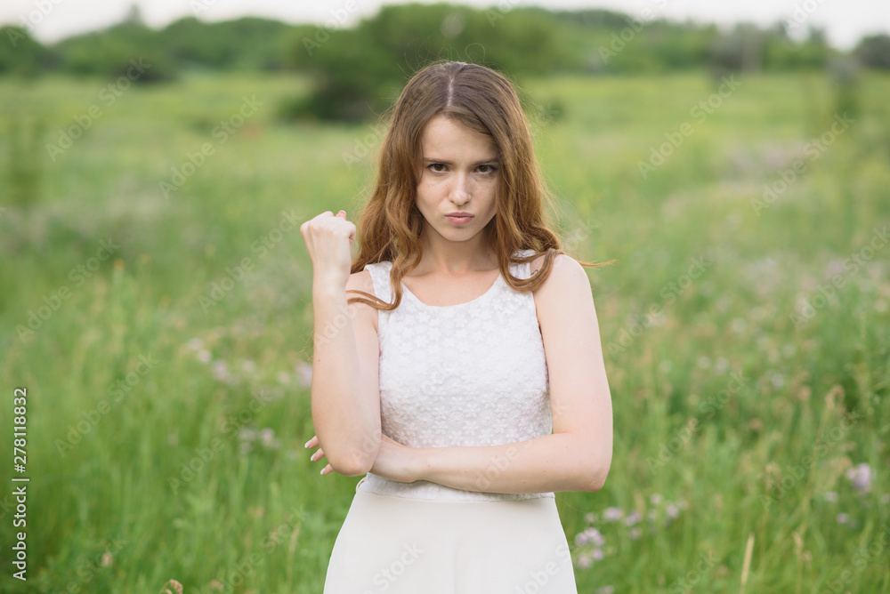 Beautiful young girl shows discontent in nature Beautiful young girl shows discontent in nature