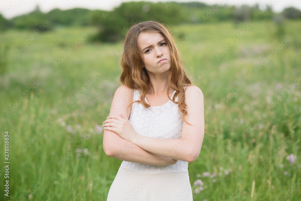 Beautiful young girl shows discontent in nature Beautiful young girl shows discontent in nature