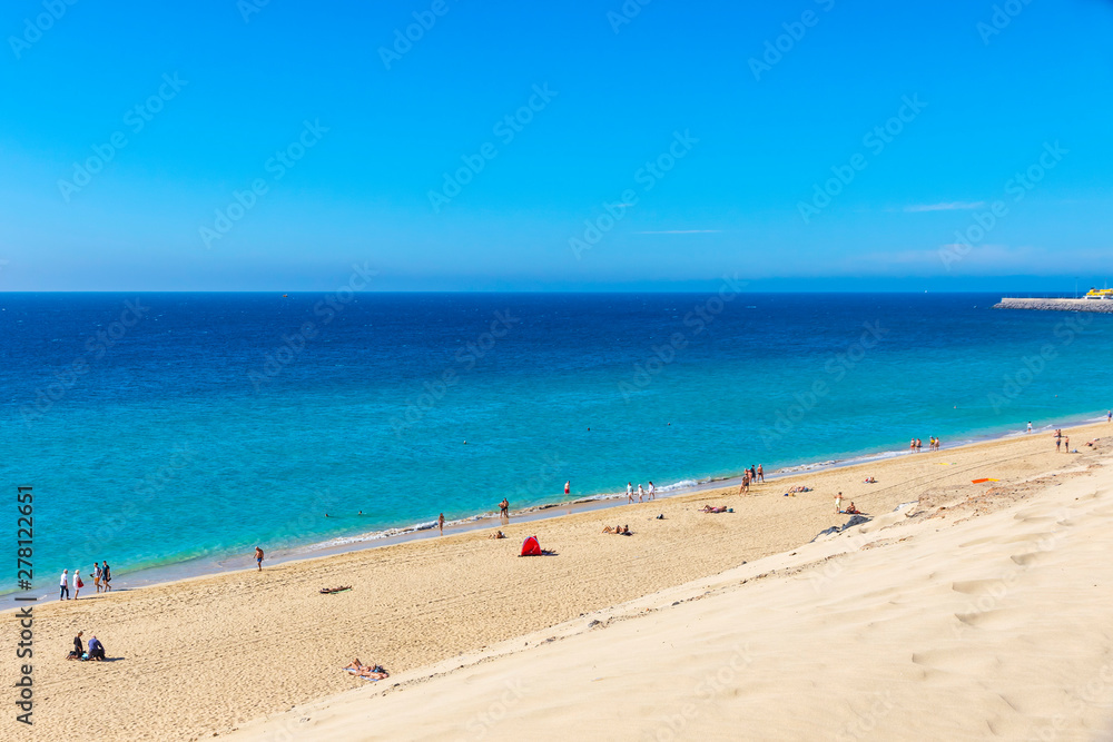 Beach in Morro del Jable town (Morro Jable beach) on Fuerteventura island, Canary Islands, Spain. One of the best beach in the Canaries. Fine yellow sand and safe shallow entry into the Atlantic ocean