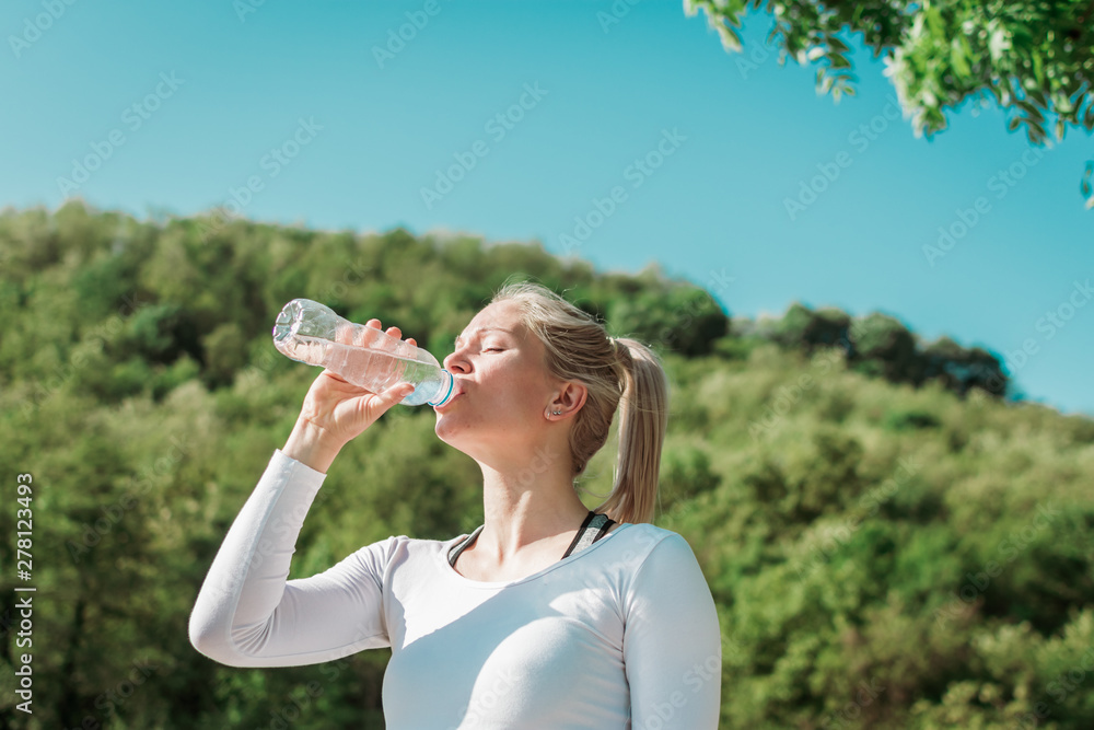 Sporty woman drinking water after her training in the morning. Sporty woman drinking water after her training in the morning.
