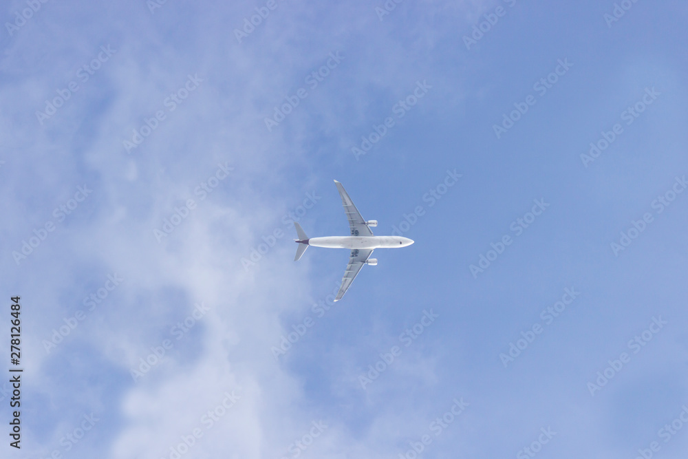 An airplane on the cloudy blue sky