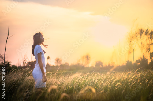 Beauty Girl Outdoors enjoying nature. Beautiful Teenage Model girl in the Spring Field, Sun Light.