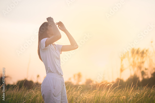 Fototapeta Naklejka Na Ścianę i Meble -  Beauty Girl Outdoors enjoying nature. Beautiful Teenage Model girl in the Spring Field, Sun Light.