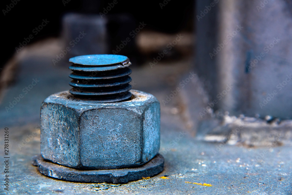 Close-up of a weathered nut bolt and washer firmly fixed into a concrete base Close-up of a weathered nut bolt and washer firmly fixed into a concrete base