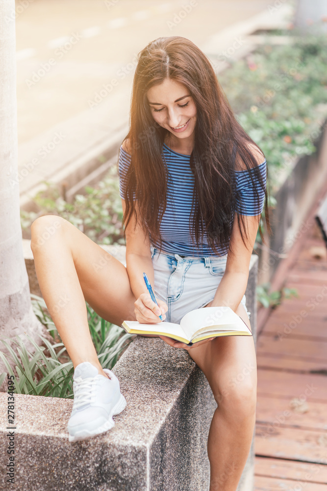 Life is full of choices. Beautiful woman in casual wear sitting with a notebook in her hands Life is full of choices. Beautiful woman in casual wear sitting with a notebook in her hands