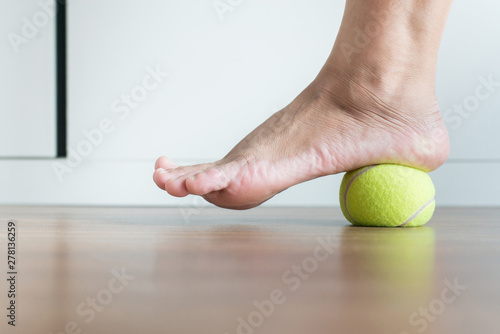 Women massage with tennis ball to her foot,Feet soles massage for plantar fasciitis