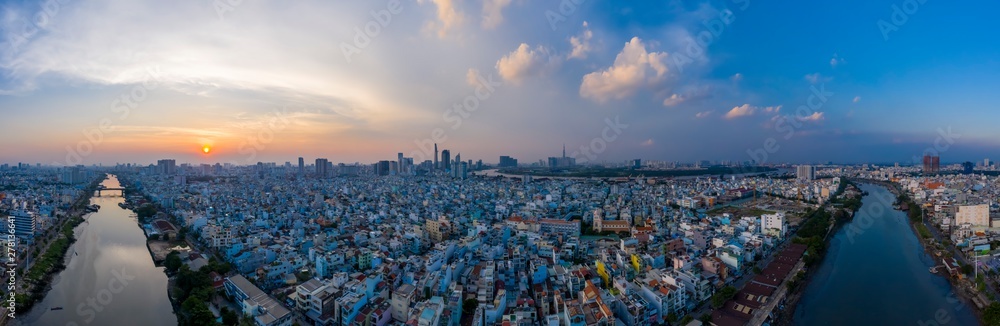 Sunset panorama of Ho Chi Minh City (Saigon) Vietnam from district 7 with canal and residential area in the foreground and city skyline in background