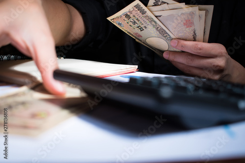 Billede på lærred A man hand counting Japanese yen on wooden table