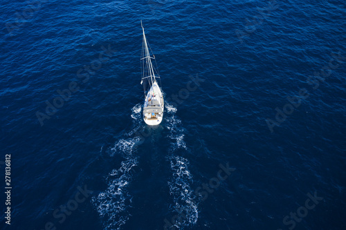 View from above, stunning aerial view of a sailboat sailing on a blue sea. Emerald coast (Costa Smeralda), Sardinia, Italy.