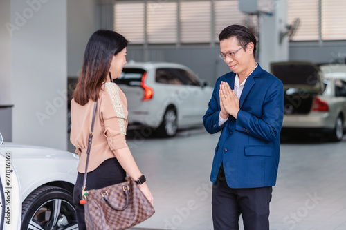 Asian receptionist welcoming the customer to visit maintainance service center for checking the car in showroom