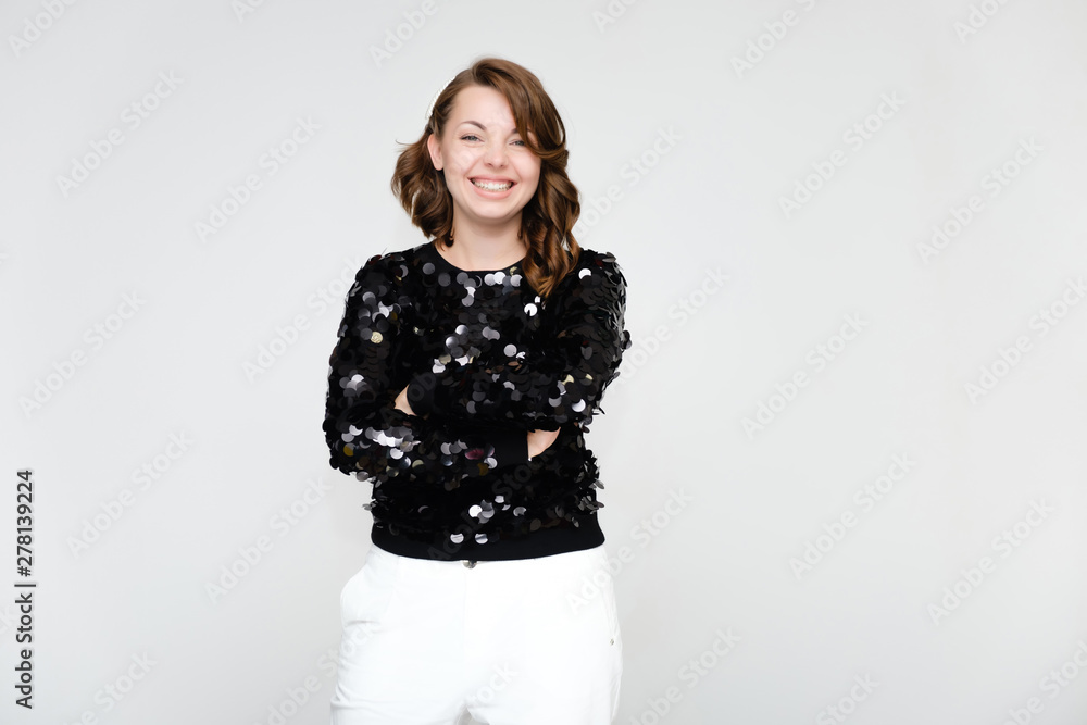 Portrait below the belt on a white background pretty young brunette woman in a black sweater and white trousers with glitters. Standing in different poses, talking, showing emotions. Portrait below the belt on a white background pretty young brunette woman in a black sweater and white trousers with glitters. Standing in different poses, talking, showing emotions.