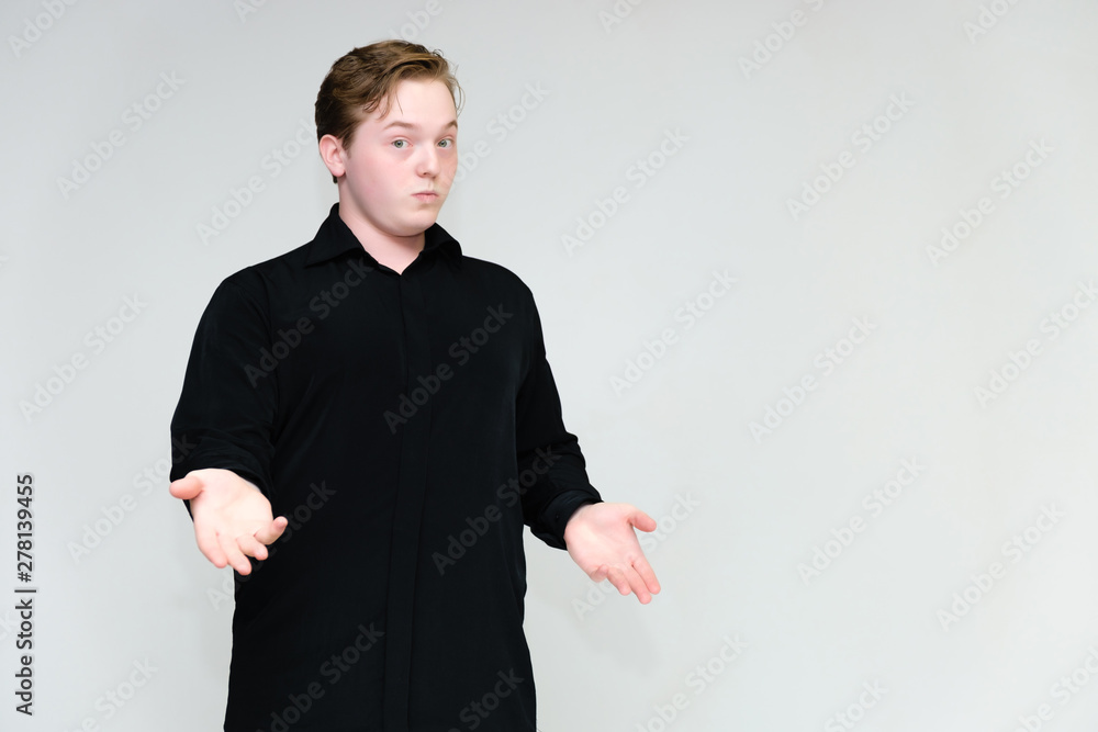 Portrait to the waist on a white background of a handsome young man in a black shirt. stands directly in front of the camera in different poses, talking, showing emotions, showing hands. Portrait to the waist on a white background of a handsome young man in a black shirt. stands directly in front of the camera in different poses, talking, showing emotions, showing hands.