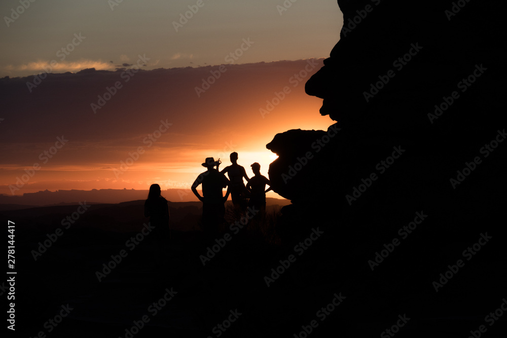 Tourists Silhouettes Watching Orange Desert Sunset - Arches National Park, Utah