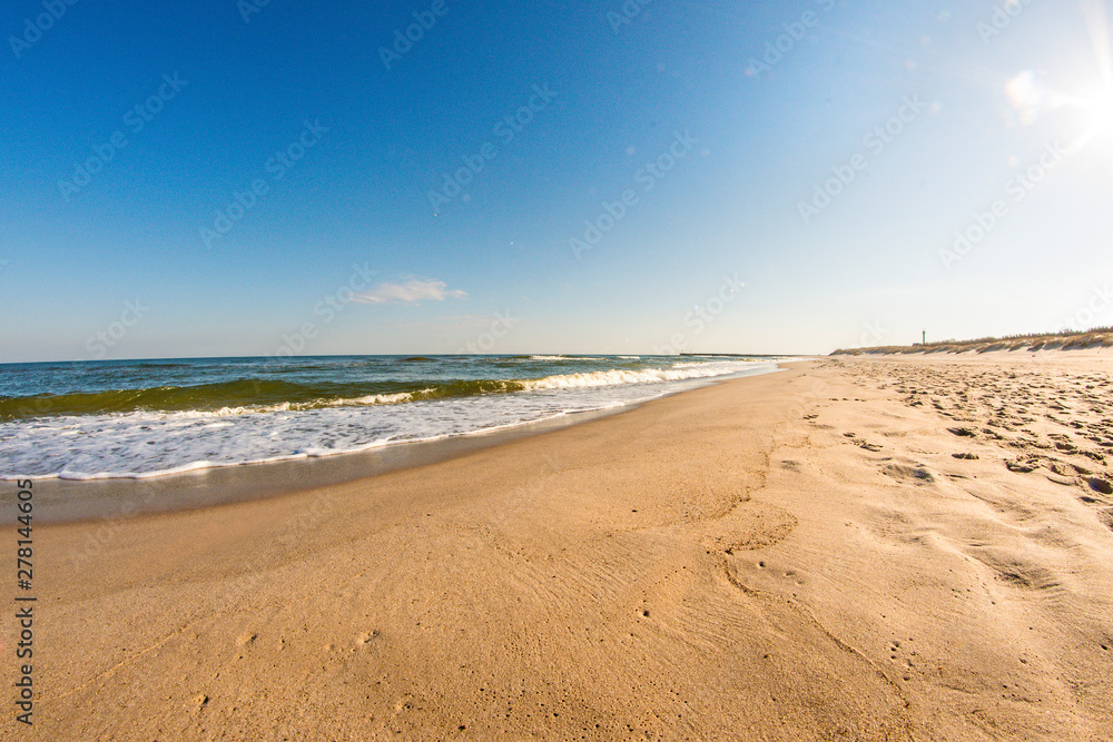 lonesome beach of the Baltic Sea with blue sky and surf