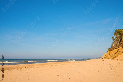Fototapeta Naklejka Na Ścianę i Meble -  lonesome beach of the Baltic Sea with blue sky and surf