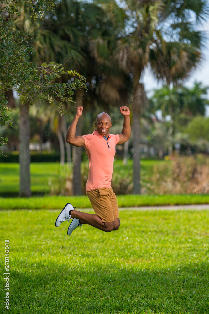 Photo of a young man jumping in the air. Action shot of a handsome male model in the park