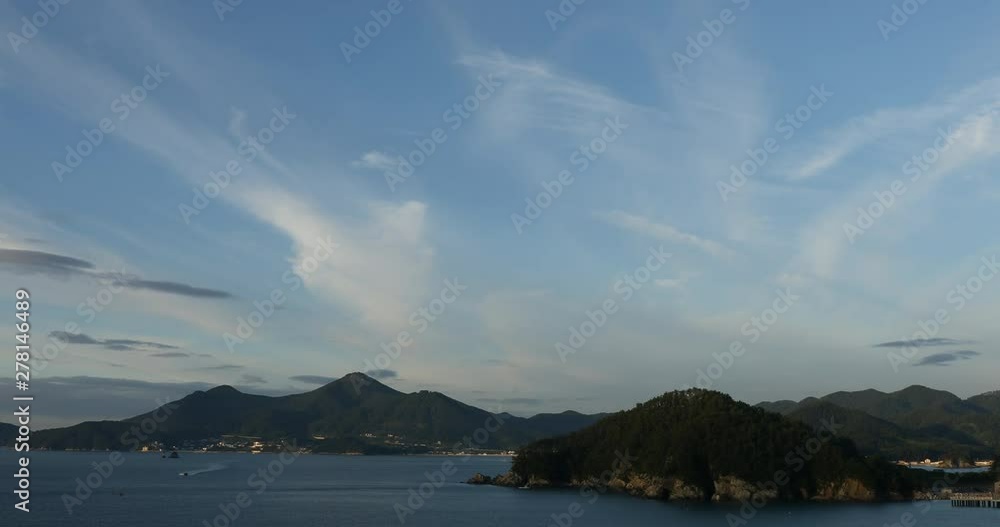 Beautiful sunset landscape of island with water waves and boat Beautiful sunset landscape of island with water waves and boat