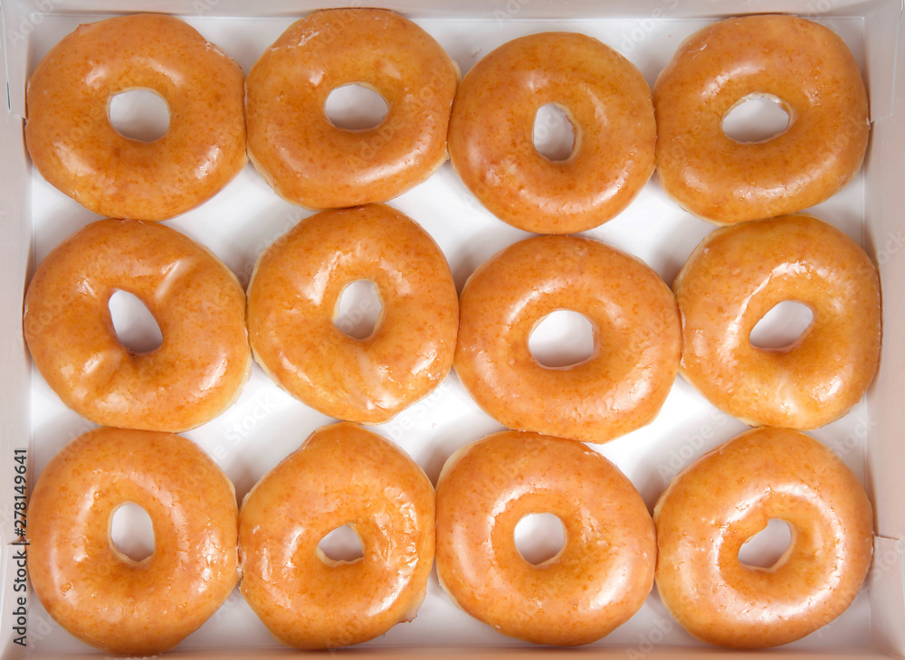 Foto de Top view flat lay of plain glazed donuts in a white box