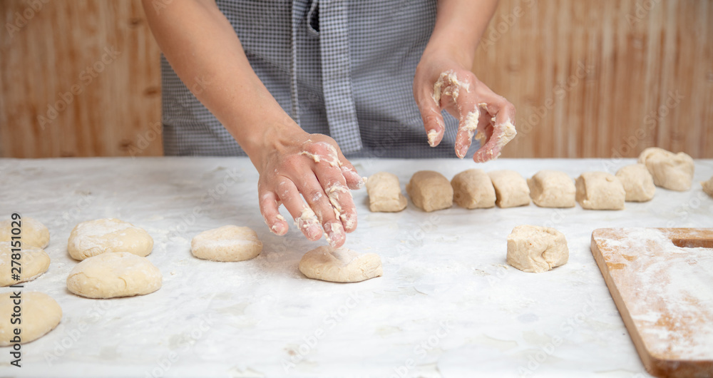 The hostess cuts the dough in the kitchen The hostess cuts the dough in the kitchen