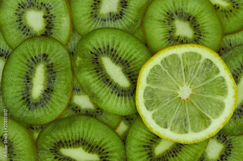 Close-up view of green kiwi and yellow lemon slices for background