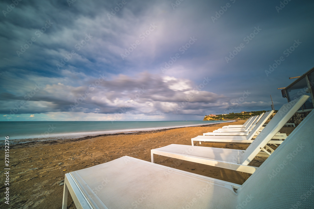 Fototapeta premium Empty white plastic sunbeds on Tsilivi Beach