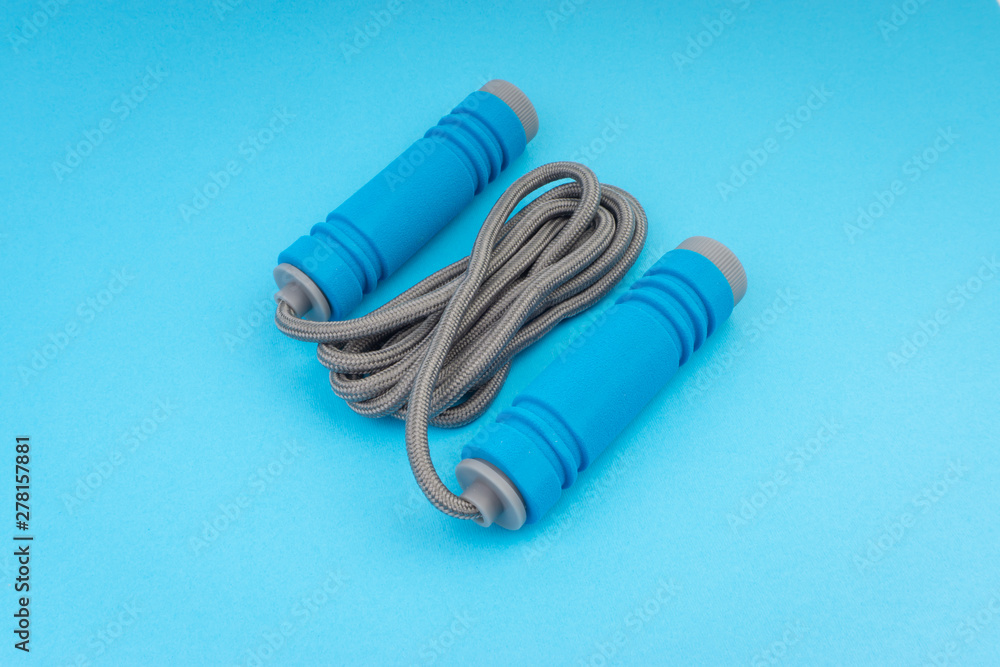 Skipping rope or jumping rope isolated on blue background. Selective focus and crop fragment Skipping rope or jumping rope isolated on blue background. Selective focus and crop fragment